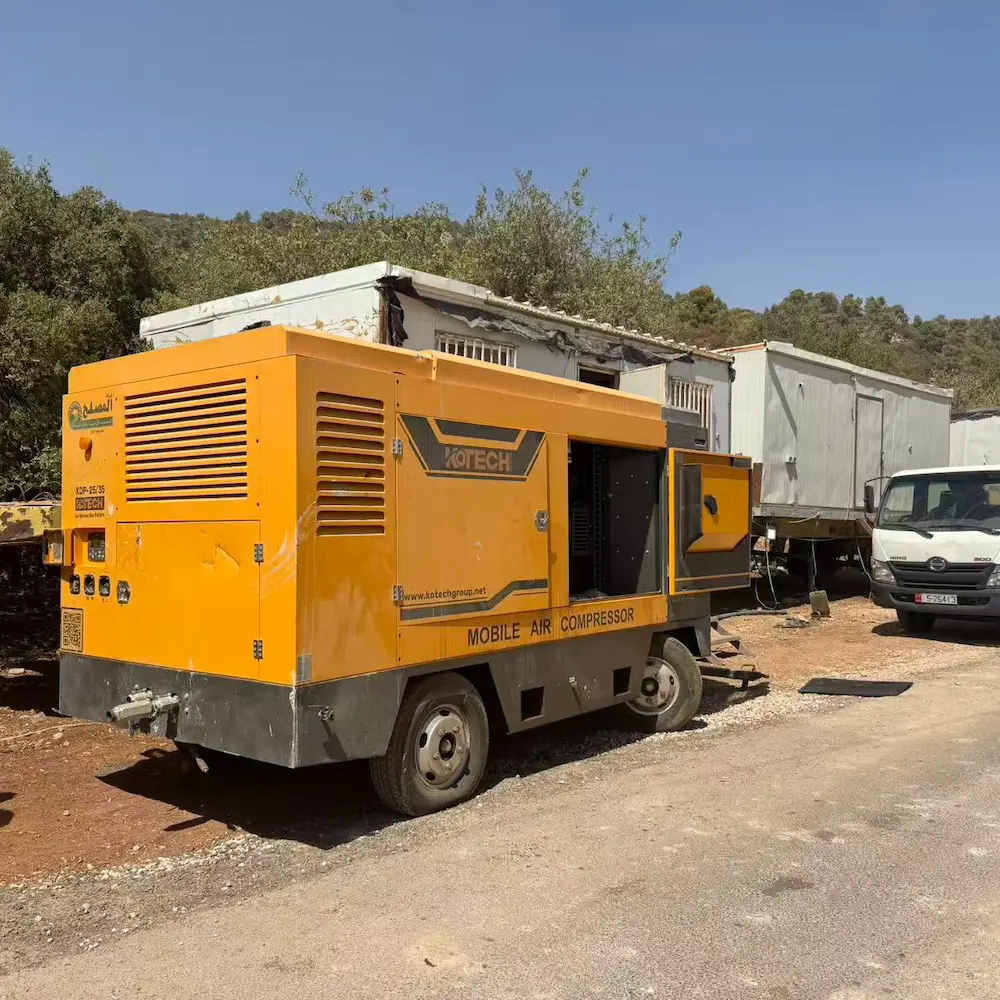Kotech KDP-25/35 twin-pressure air compressor powering a water well drilling rig in Jordan's Disi aquifer desert